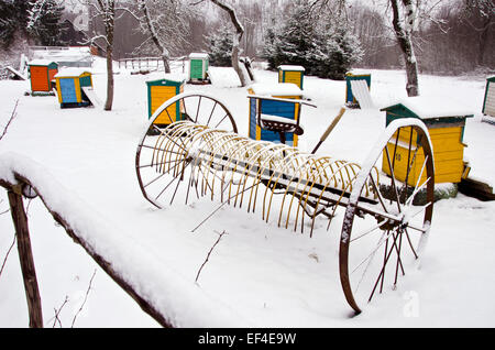 Vieux cheval de neige hay rake et ruche en hiver groupe jardin ferme Banque D'Images
