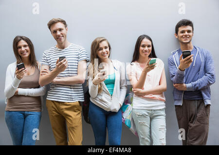 Les élèves à l'aide de leurs smartphones dans une rangée Banque D'Images