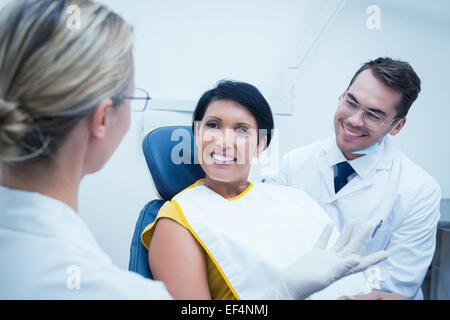 Smiling dentiste et l'assistant with female patient Banque D'Images