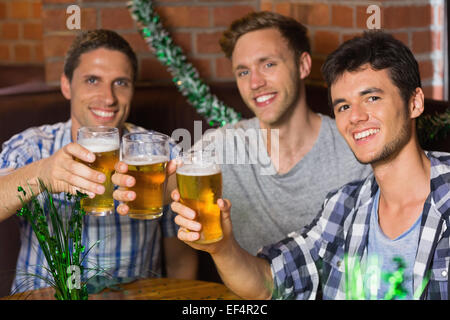 Happy friends toasting with pintes de bière sur patricks day Banque D'Images