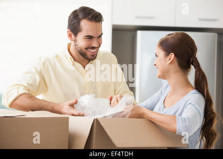 Jeune couple unpacking boxes in kitchen Banque D'Images