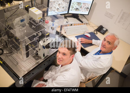 Biochimiste et student looking at images microscopiques sur ordinateur Banque D'Images