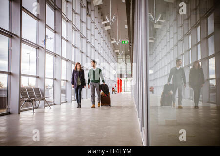 Jeune couple avec lugggage en bâtiment de l'aéroport Banque D'Images