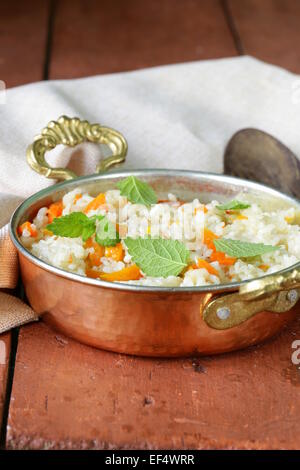 Riz avec légumes cuits dans le style indien dans une casserole en cuivre Banque D'Images