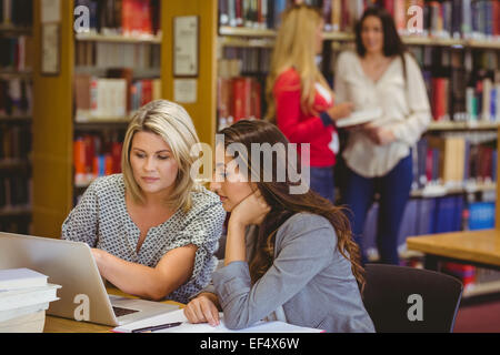 Les deux autres élèves sur ordinateur portable avec ses camarades derrière eux Banque D'Images