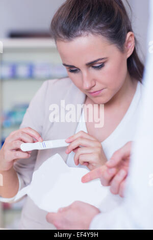 Young Woman Reading test de grossesse Banque D'Images