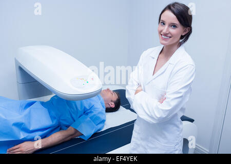 Smiling doctor avec un patient sous l'appareil à rayons x Banque D'Images