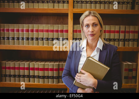 Portrait d'un bibliothécaire à poser et tenant un livre Banque D'Images