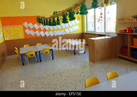 Classe de maternelle avec des chaises et une table jaune Banque D'Images