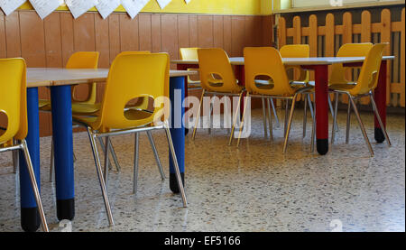 Classe de maternelle avec des chaises et une table jaune Banque D'Images