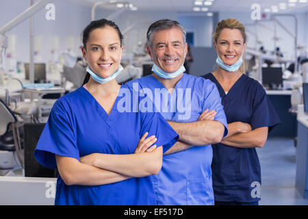 Portrait of smiling co-travailleurs dans une ligne avec les bras croisés Banque D'Images