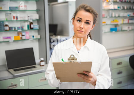 Pharmacien Junior writing on clipboard Banque D'Images