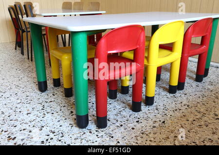 Des chaises en plastique de couleur et de petites tables dans la classe maternelle Banque D'Images