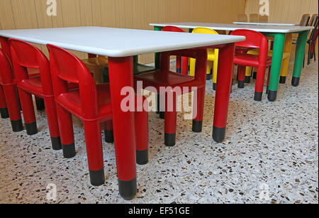 Des chaises en plastique de couleur et de petites tables dans la classe de maternelle Banque D'Images