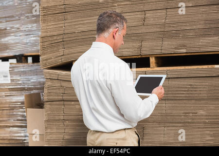 Manager using digital tablet in warehouse Banque D'Images