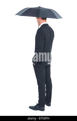 Businessman s'abritant sous parapluie noir Banque D'Images
