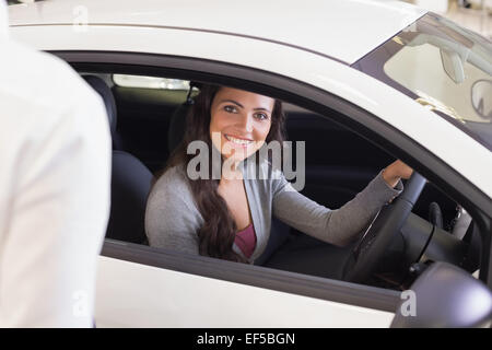 Heureux conductrice au volant assis dans sa voiture Banque D'Images
