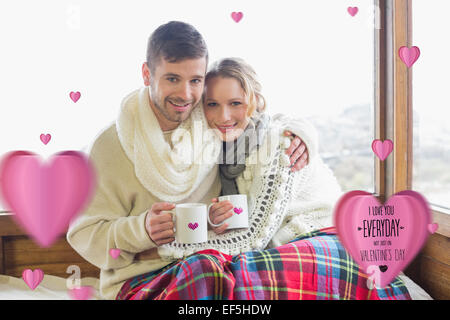 Image composite du couple aimant en hiver l'usure avec fenêtre contre tasses Banque D'Images