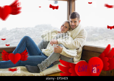 Image composite du couple dans les vêtements d'hiver assis contre la fenêtre de cabine Banque D'Images