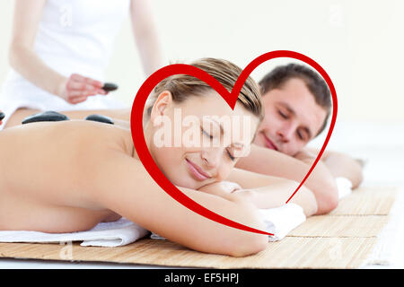 Image composite de young couple having a massage aux pierres chaudes Banque D'Images