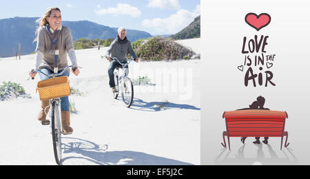 Image composite de carefree couple partir en promenade en vélo sur la plage Banque D'Images