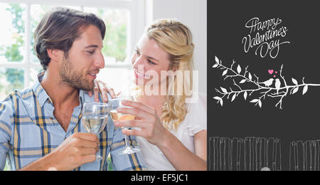 Image composite de cute smiling couple enjoying white wine Banque D'Images