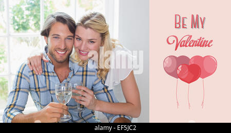 Image composite de cute smiling couple enjoying white wine Banque D'Images