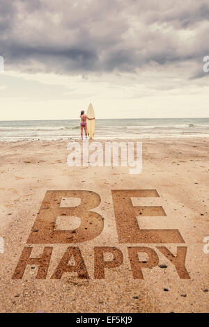 Image composite de calm woman in bikini with surfboard on beach Banque D'Images