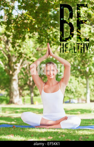 Image composite de cute young woman doing yoga assis sur un tapis d'exercice Banque D'Images