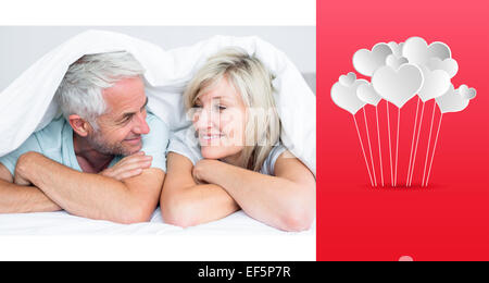 Image composite de libre d'un mature couple Lying in Bed Banque D'Images