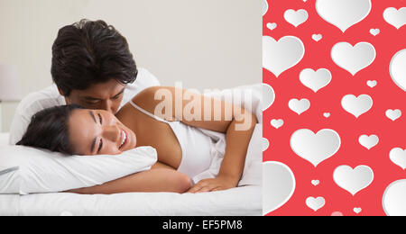 Image composite du couple Lying in Bed et de câlins Banque D'Images