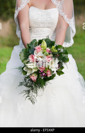 Mariée avec bouquet de roses blanches et roses, pas de visage Banque D'Images