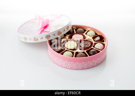 Boîte de chocolats rose avec ruban sur fond blanc Banque D'Images