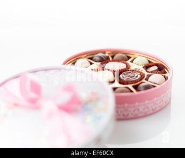 Boîte de chocolats rose avec ruban sur fond blanc Banque D'Images