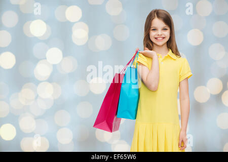 Smiling little girl in dress with shopping bags Banque D'Images