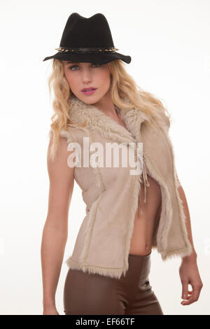 Blond woman wearing beige fausse fourrure gilet & black hat Banque D'Images
