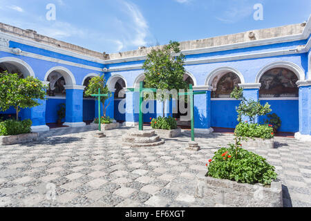 Cour murée bleu avec des piliers et des arcades du cloître et trois croix de bois vert dans l'emblématique Couvent Santa Catalina à Arequipa, Pérou Banque D'Images