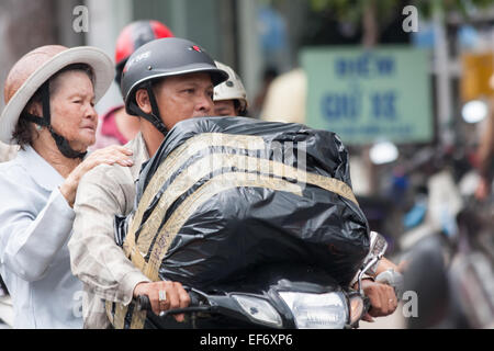 L'homme et la femme transportant un grand colis sur une moto à Ho Chi Minh Ville, Vietnam Banque D'Images