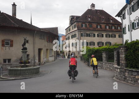 Deux cyclistes de randonnée équestre à travers le village de Chur, Suisse. Banque D'Images