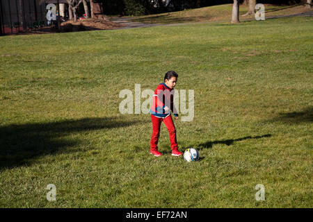 Garçon jouant au football latino à pioneer park, Novato, Californie, USA Banque D'Images