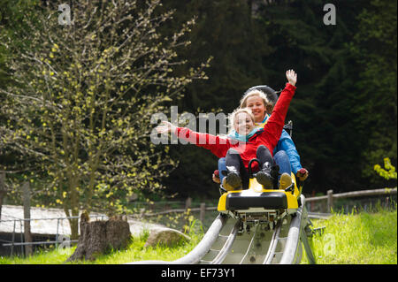 Les jeunes femmes sur une piste de luge d'été, dans le Steinwasenpark Oberried, Forêt-Noire, Bade-Wurtemberg, Allemagne Banque D'Images