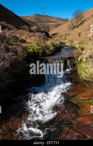 Cascade de Fairbrook dans le Peak District avec vue en amont vers le bord nord de Kinder Scout. Un jour de printemps ensoleillé. Banque D'Images