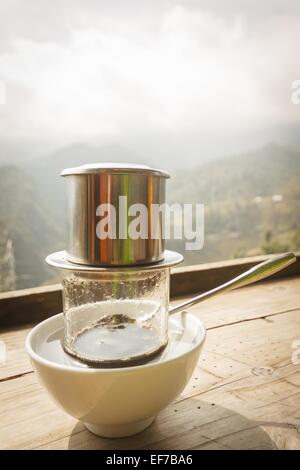 Dégoulinant de café retro style vietnamien de l'humeur sur table en bois. Banque D'Images