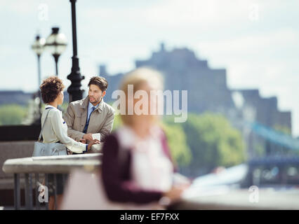 Business people talking on city waterfront Banque D'Images