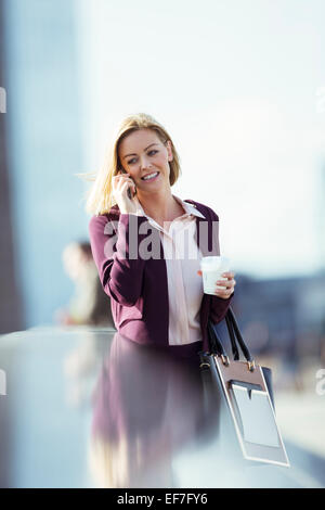 Businesswoman talking on cell phone in city Banque D'Images