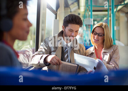 Business people talking on train Banque D'Images