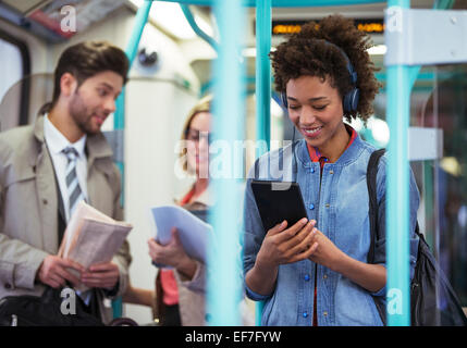 Woman using digital tablet on train Banque D'Images