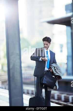 Businessman checking sa montre en gare Banque D'Images