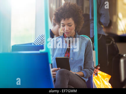 Woman using digital tablet on train Banque D'Images