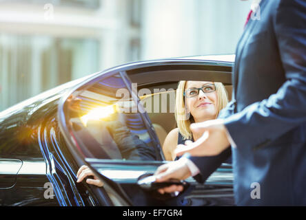 Ouverture de porte de voiture avec chauffeur pour businesswoman Banque D'Images